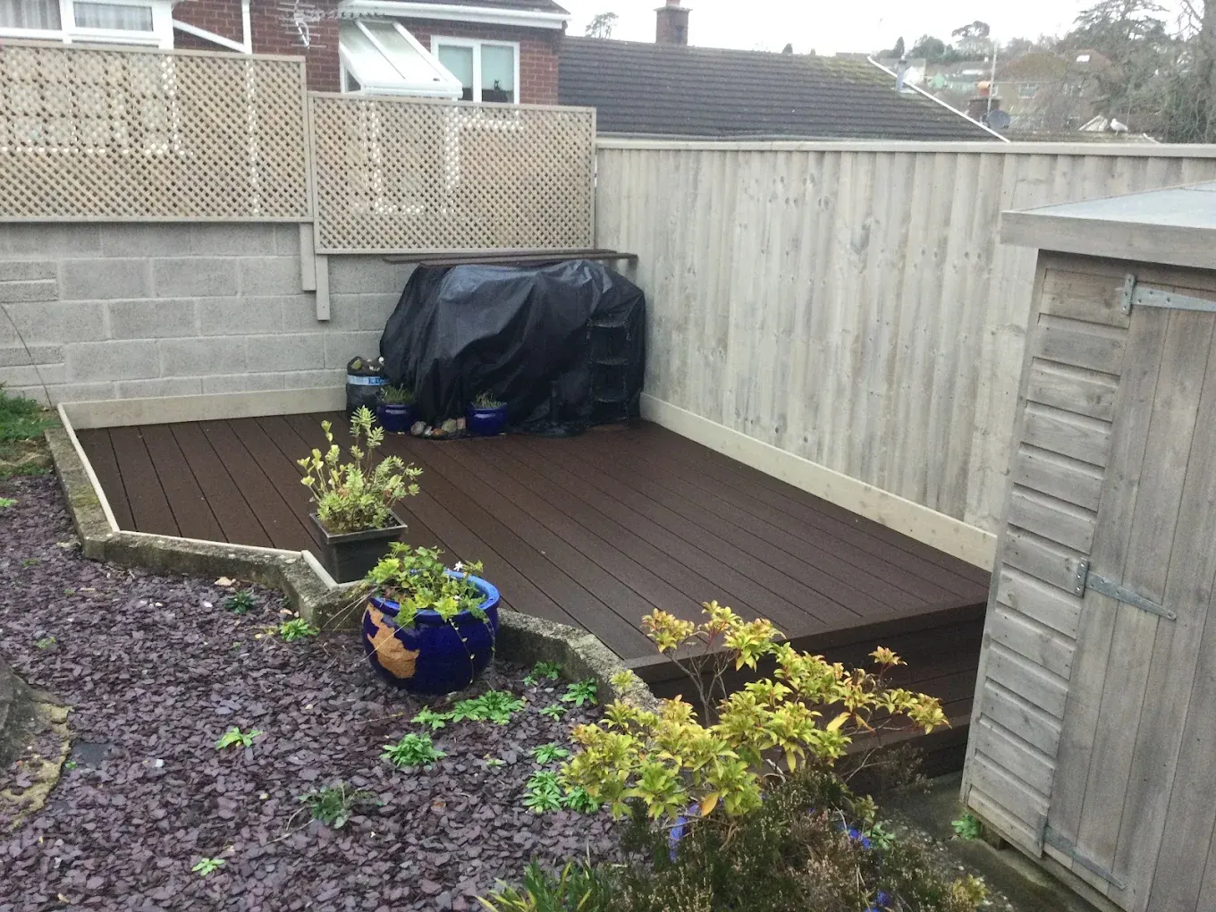 Brown composite deck laid across an enclosed garden