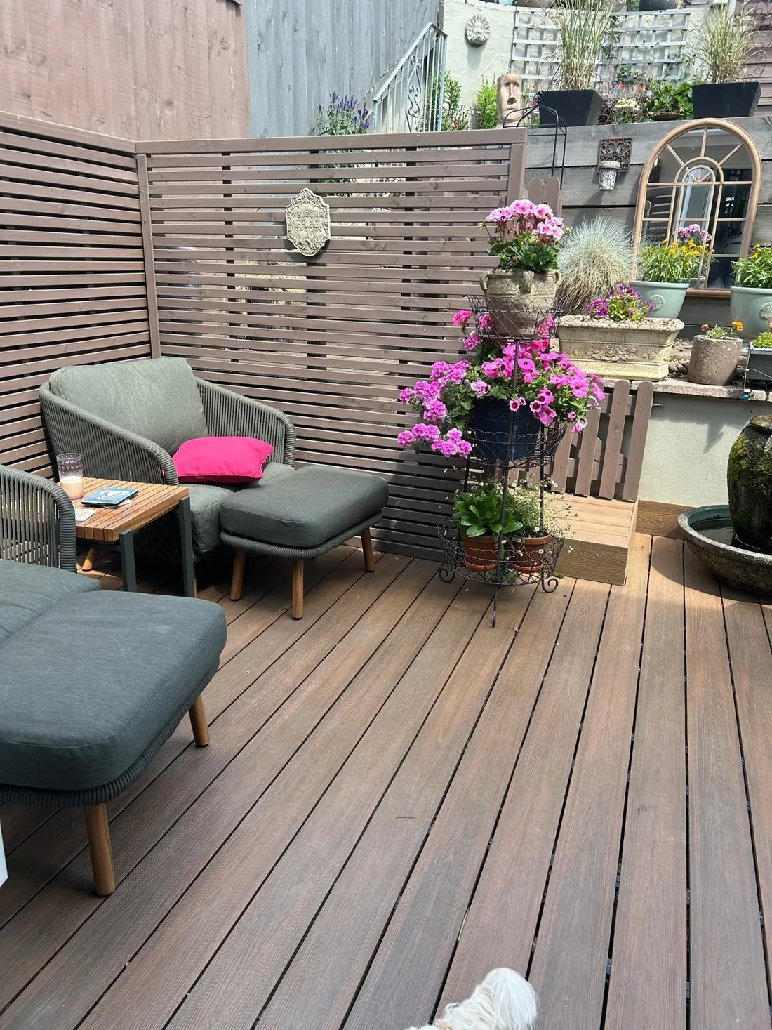 Brown composite deck in a courtyard garden with a horizontal slatted privacy screen