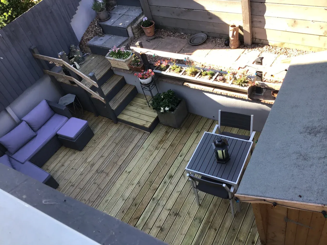 Timber decking courtyard with steps up to a seating area in Newton Abbot